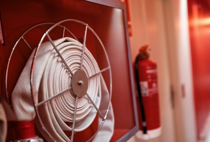 Fire extinguisher and fire hose reel in hotel corridor